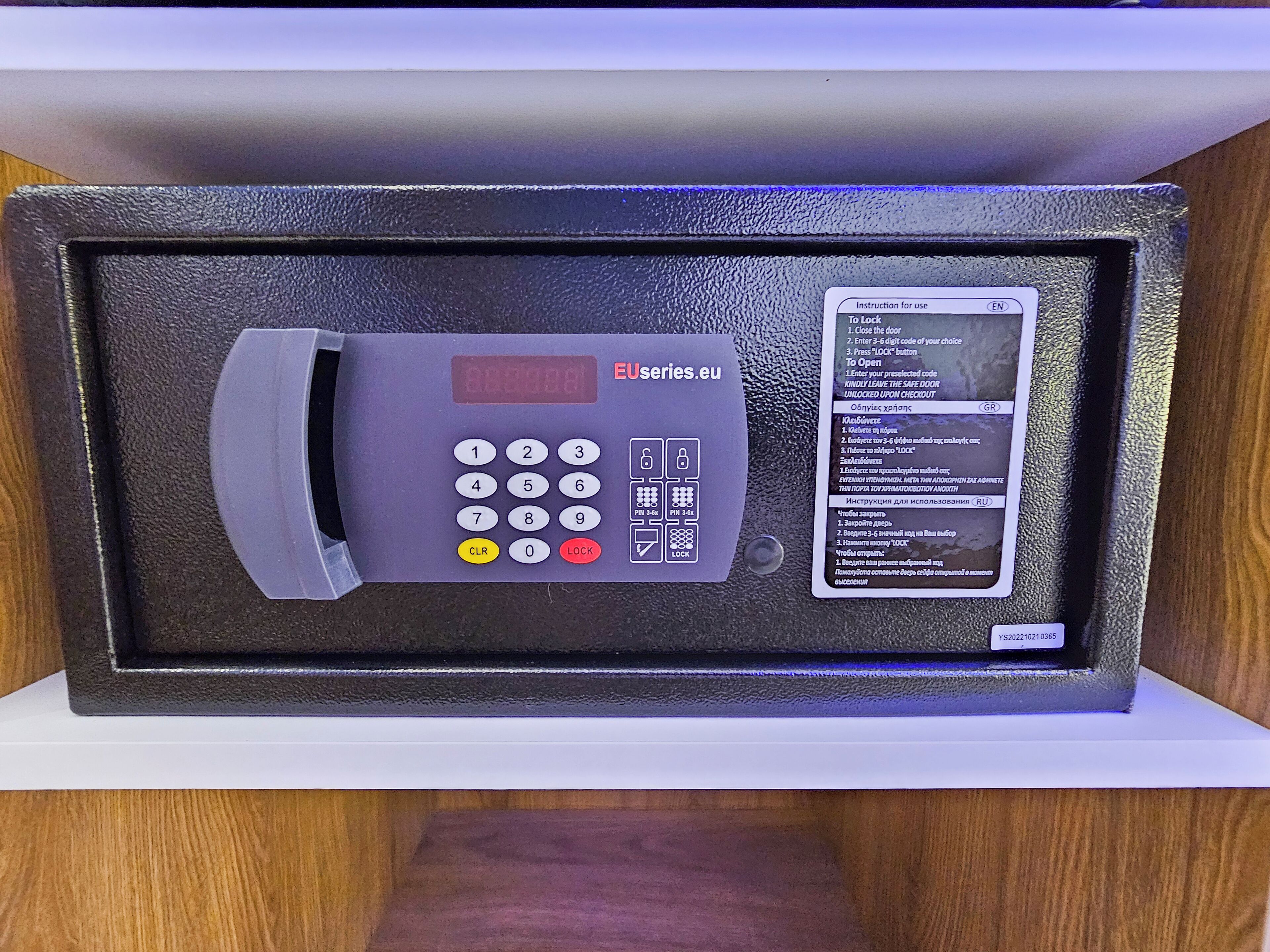 A secure electronic lock with a keypad and a digital display, accompanied by multilingual instructions.