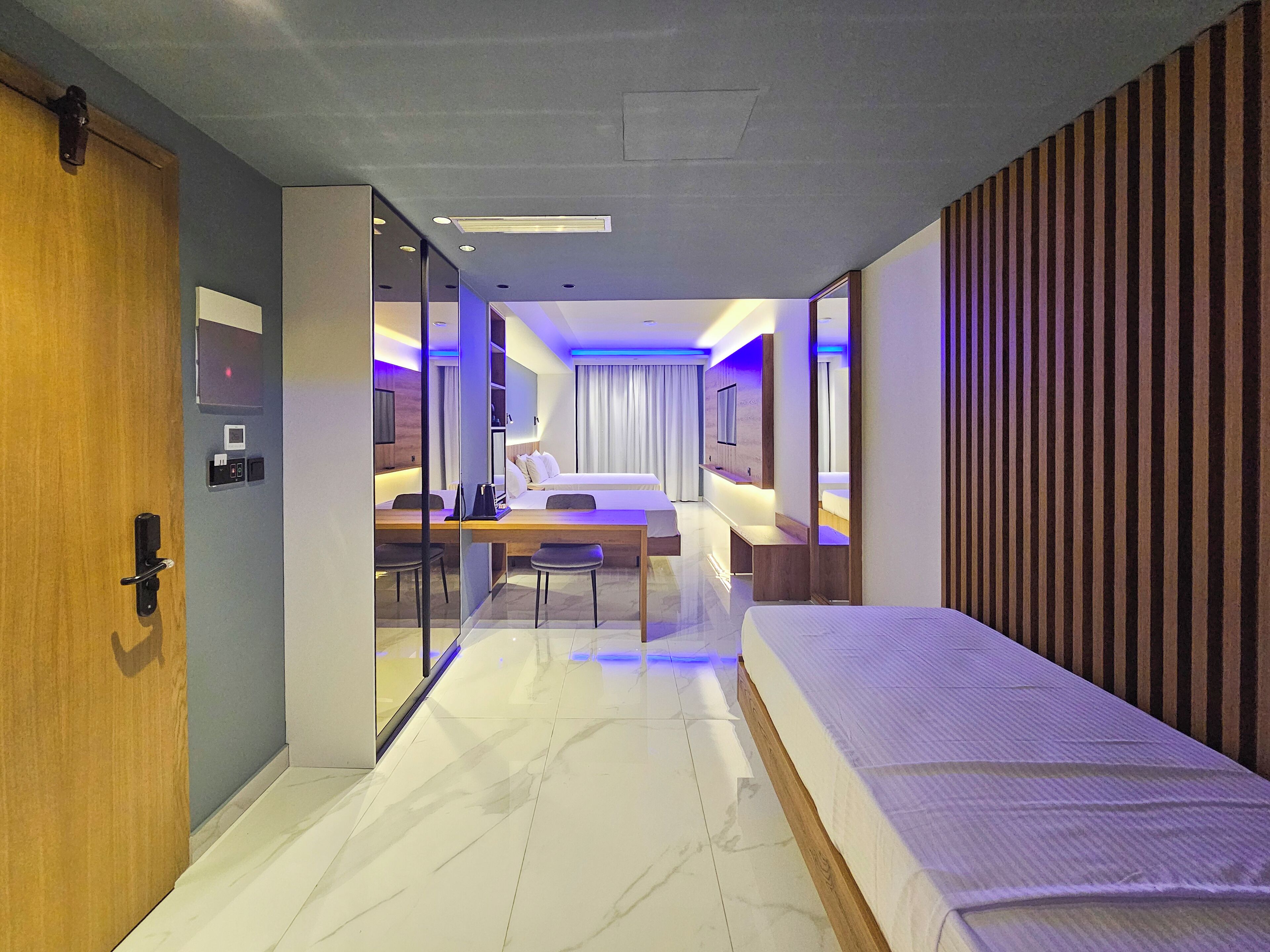 Une chambre d’hôtel moderne équipée d’un lit, d’un bureau et d’un coin salon.