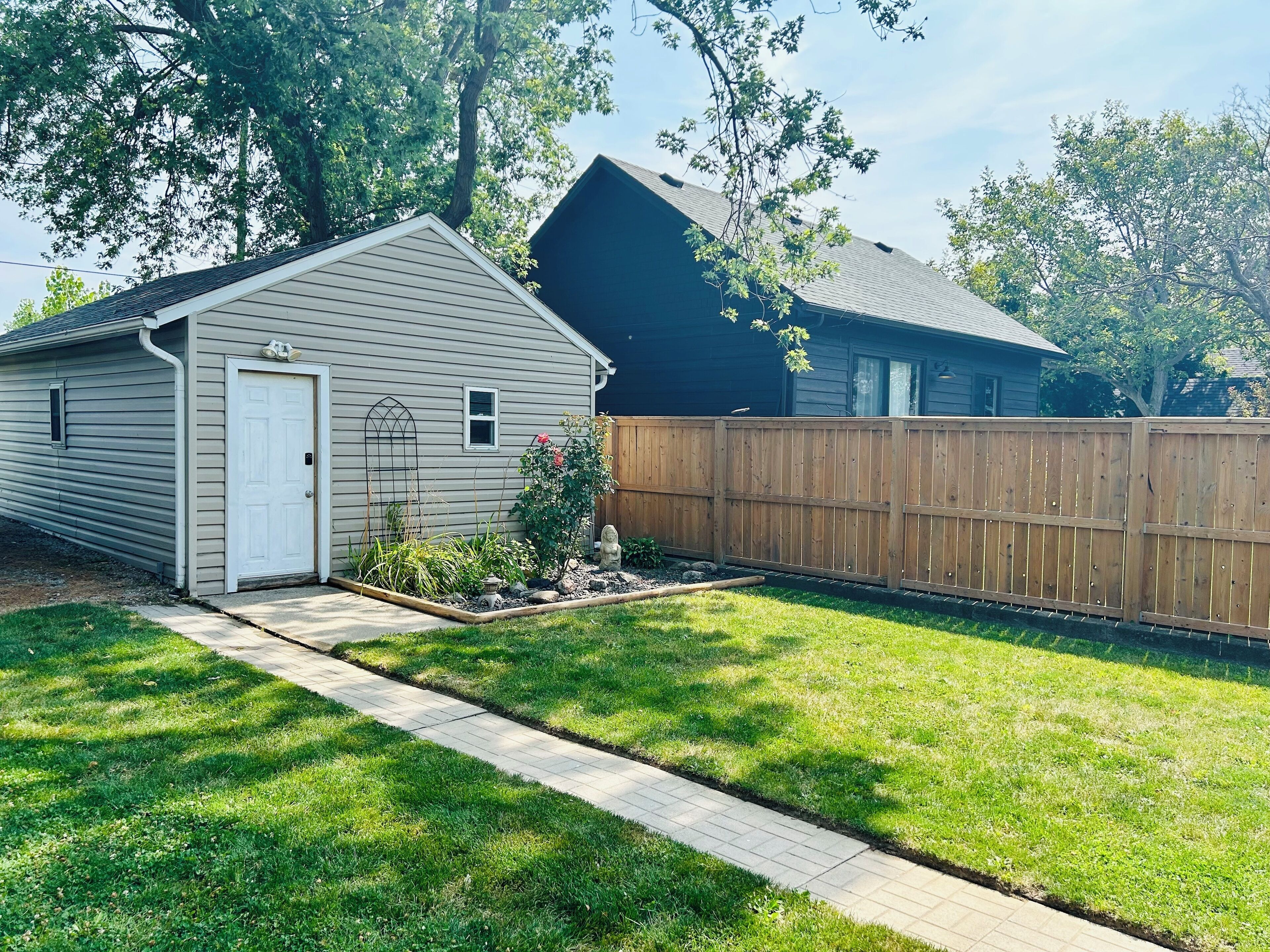 A residential property with a garage, a wooden fence, and a well-maintained lawn.