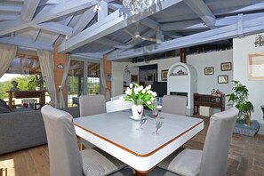 A covered patio area with a dining table, chairs, and a vase of flowers. - Villa Borgiano in Scansano (Scansano)