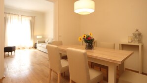 A dining area with a wooden table, beige chairs, and a vase of flowers. - Palagio 1 in Chianti With Shared Pool (Rignano sull'Arno)