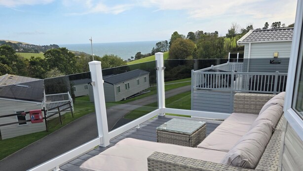 A balcony with wicker furniture and a view of the sea. - Ty-dee Holiday Home Inside Polperro Holiday (Looe)