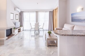 Relax in this spacious living area with a fireplace, plush sofa, and flat-screen TV.
