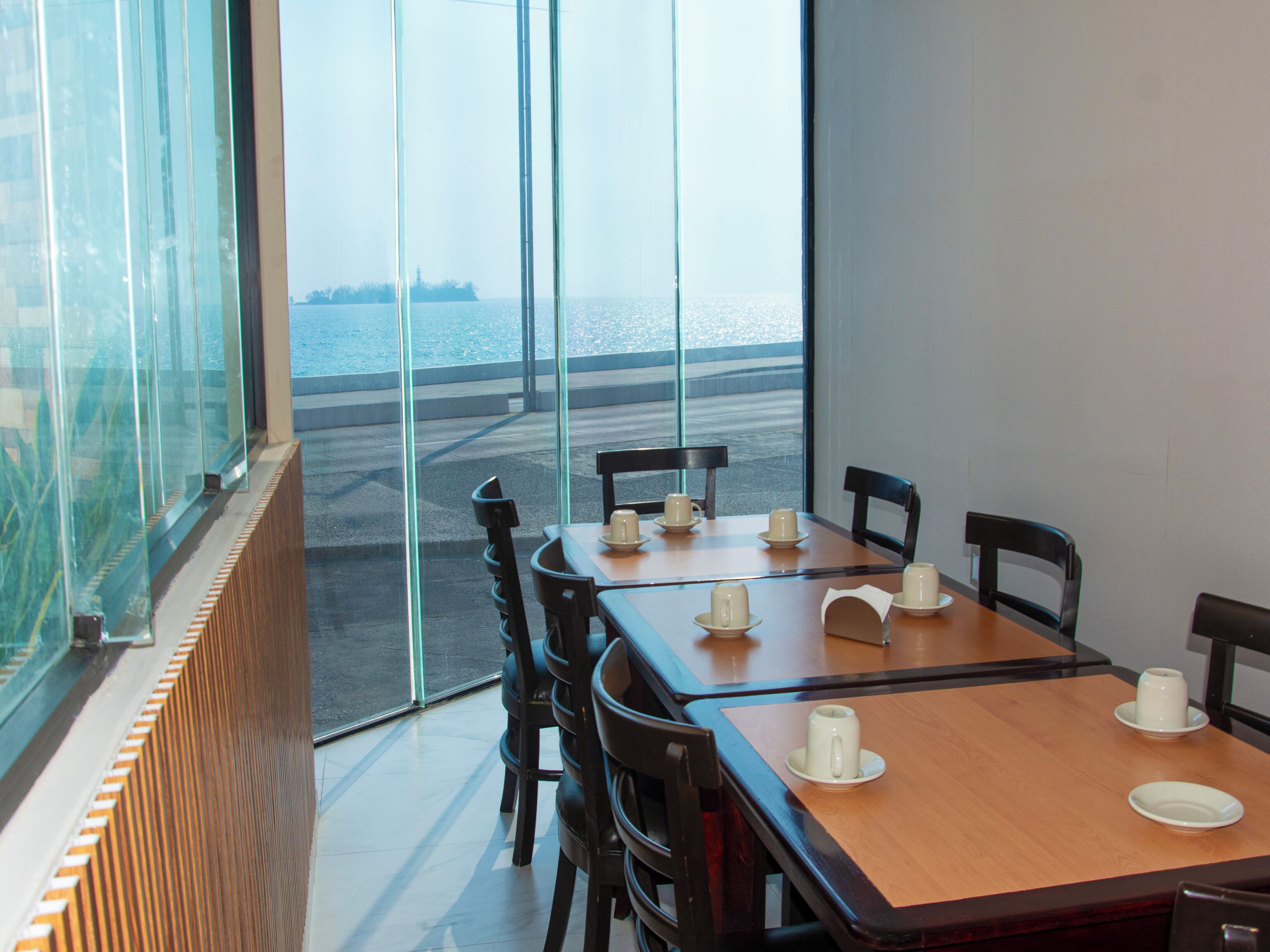 Un comedor con vistas al mar a través de amplios ventanales.
