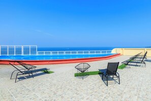 Una piscina al aire libre, sillones reclinables de piscina