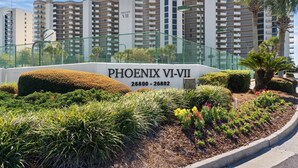 En skylt för Phoenix VI–VII med en vackert anlagd trädgård framför.