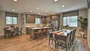 Une cuisine spacieuse dotée d’un plancher en bois, d’un îlot central et d’appareils électroménagers modernes.