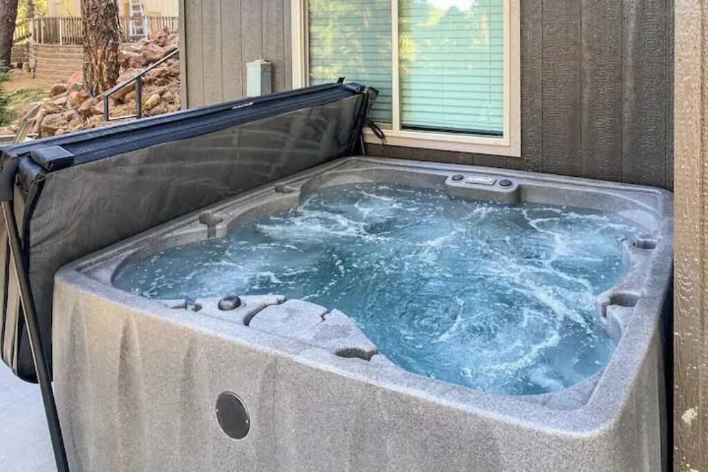 A hot tub with a stone exterior, a window to the side, and a metal cover.