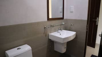 A bathroom with a white sink, a mirror, and a toilet.