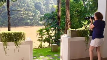 Una persona usando una cámara en una habitación con vistas a un jardín y un sendero.