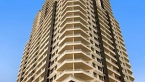 A high-rise hotel with multiple balconies, a prominent entrance, and a visible restaurant area at the ground level. - Pandanas Apt 7 (15th fl with harbour & city views) (Darwin City)