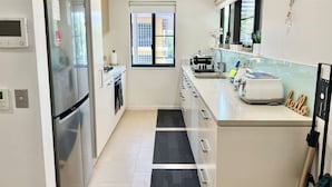 A modern kitchen with stainless steel appliances, a window, and a view of the outside.