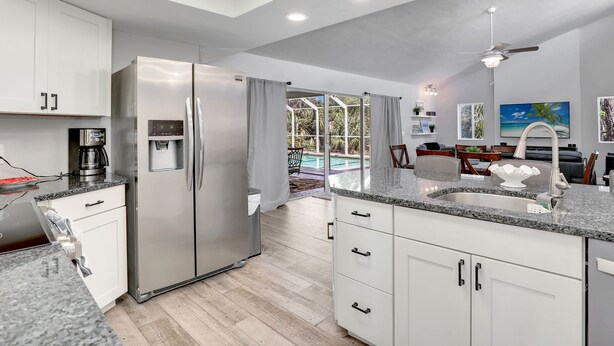 A modern kitchen with a built-in refrigerator, a coffee maker, and a water dispenser.
