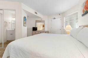 Relax in this serene bedroom with a large bed, TV, and comfortable seating area.