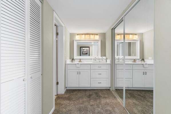 Bathroom features a walk-in shower, double sink, and large mirror.