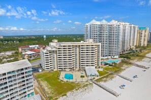 Enjoy stunning views of the coastline from the rooftop pool surrounded by lush greenery and a sandy beach area.