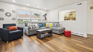 A modern living room with a sectional sofa, a dark armchair, and a coffee table.