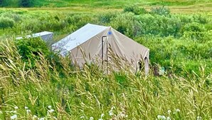A tent in a grassy field with trees in the background. - “Queen's Quarters” Cozy Outdoor Glamping • Hot Tub (Monument)