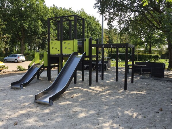 A playground with two slides and a climbing structure. - Nice Tent Lodge With Veranda (IJhorst)
