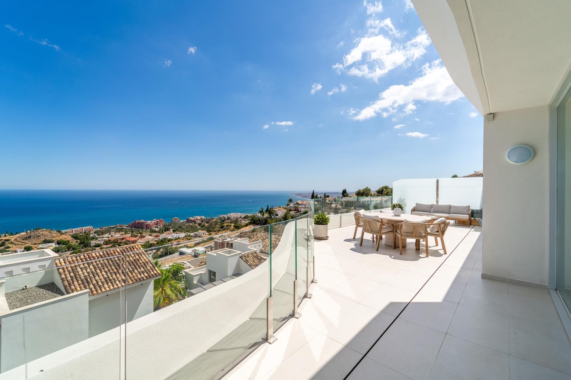 A balcony with a view of the sea and a cityscape.