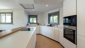 Una cucina moderna con mobili bianchi, forno integrato e microonde.