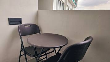 Een klein balkon met een ronde tafel en twee stoelen.