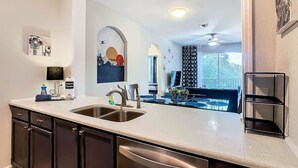 Una cocina moderna con una isla grande, electrodomésticos de acero inoxidable y vista al área de comedor.