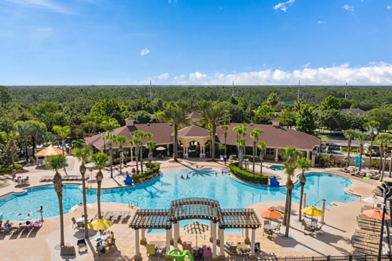A resort with a large central pool, multiple smaller pools, and a variety of outdoor seating areas.