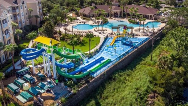 Un complejo turístico con varias piscinas, toboganes acuáticos y una amplia zona de parque acuático.