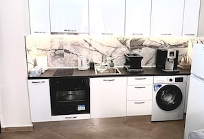 A compact kitchen with a dishwasher, oven, microwave, and a washing machine.
