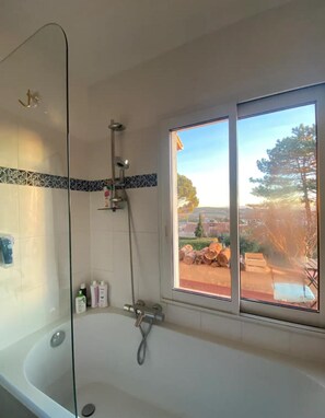 Een douche, handdoeken, zeep, toiletpapier