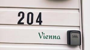 A white door with the number 204 and the word "Vienna" in green. - Chalet Vienna (Menaam)