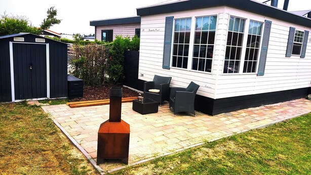 A modern house with a patio, a barbecue grill, and outdoor seating. - Chalet Vienna (Menaam)