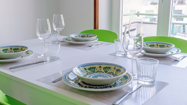 A dining table set with plates, bowls, glasses, and cutlery.