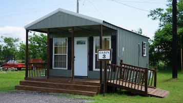 A small cabin with a porch and a sign indicating it is Cabin 3.