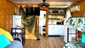 Ein gemütliches Zimmer mit einem Bett, einem Schreibtisch und einer Küchenzeile.