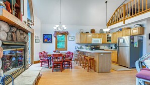 Une cuisine spacieuse avec des meubles en bois, un îlot central et une cheminée en pierre.
