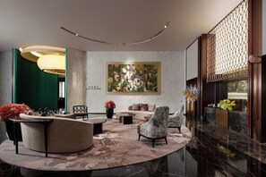 A modern lobby with a sofa, armchairs, a coffee table, and a large painting on the wall. - Jin Jiang Hua Ting Hotel and Towers (Shanghai)