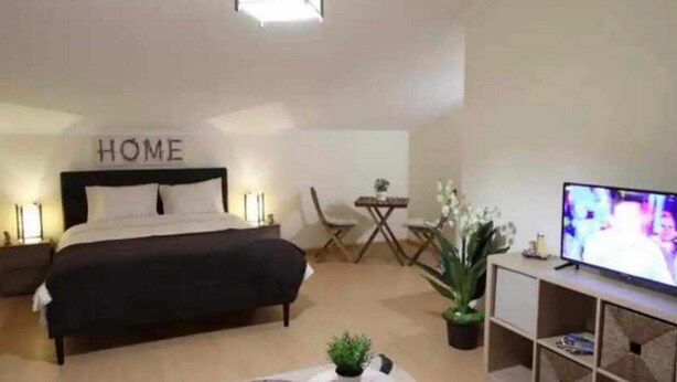 Une chambre à coucher avec un lit, une télévision, un bureau et une chaise.