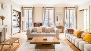 Un salon spacieux comprenant un ensemble de canapés, une table basse et une bibliothèque.