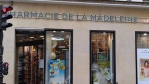 Une devanture de magasin avec l’enseigne « PHARMACIE DE LA MADELEINE » et un panneau indiquant « PUITS » au-dessus de l’entrée.
