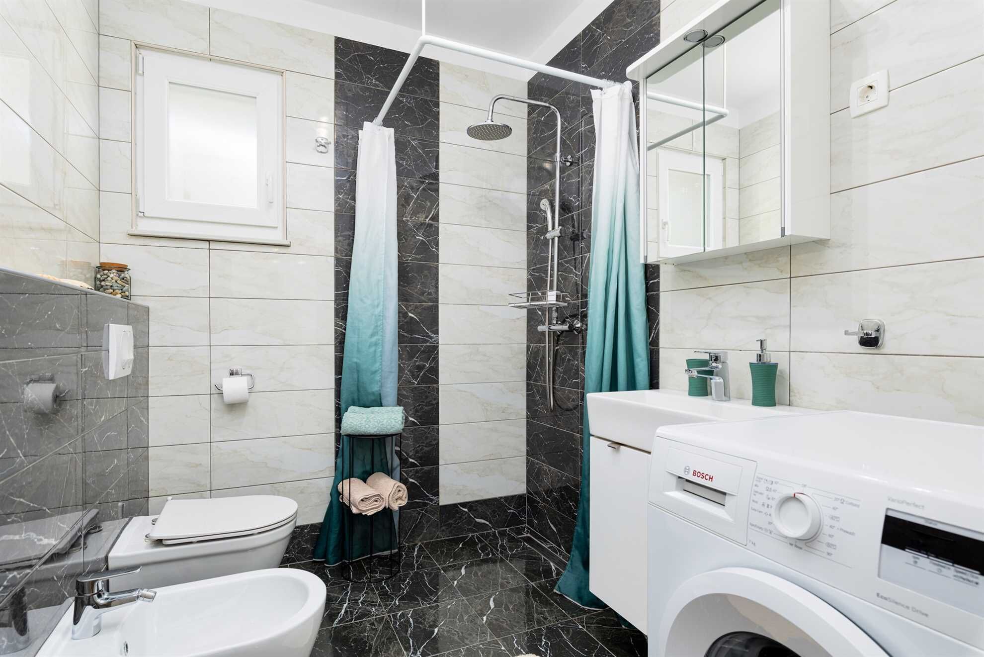 A modern bathroom with a toilet, bidet, and a Bosch washing machine.