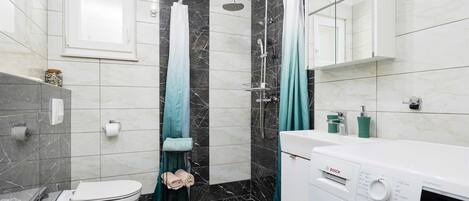 A modern bathroom with a toilet, bidet, and a Bosch washing machine.