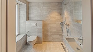 Un baño moderno con inodoro, ducha y lavamanos.