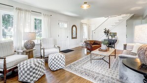 A spacious living room with a staircase, white walls, and hardwood flooring. - Spacious 5bdrm house with AC and WiFi /Family Friendly/Fire Pit /HOT TUB (Gordonville)