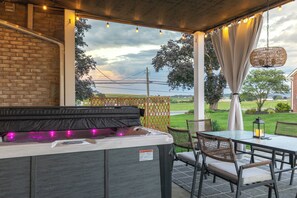 A patio area with a hot tub, outdoor seating, and a view of the countryside. - Spacious 5bdrm house with AC and WiFi /Family Friendly/Fire Pit /HOT TUB (Gordonville)