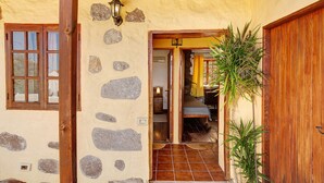 A rustic building with a stone facade, wooden beams, and a wooden door.