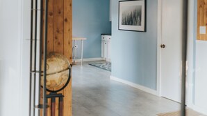 A hallway with wooden beams, a white door, and a framed picture on the wall.