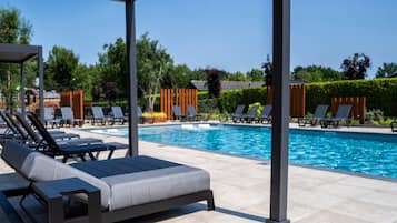 A poolside area with lounge chairs and a covered seating area.