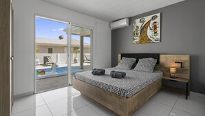 Um quarto moderno com uma cama grande, uma mesa de cabeceira e um quadro na parede.